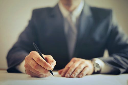 DIY estate planning, slightly blurred of sitting at a desk signing a form